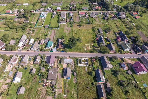 panoramic aerial view of eco village with wooden houses gravel road gardens and orchards