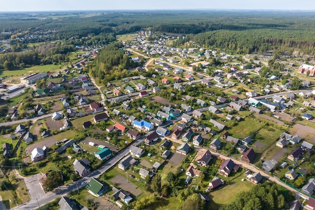 panoramic aerial view of small provincial town or big eco village with wooden houses gravel road gardens and orchards