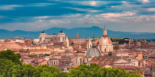 Panoramic aerial wonderful view of Rome with Altar of the Fatherland and churches at sunset time in Rome, Italy