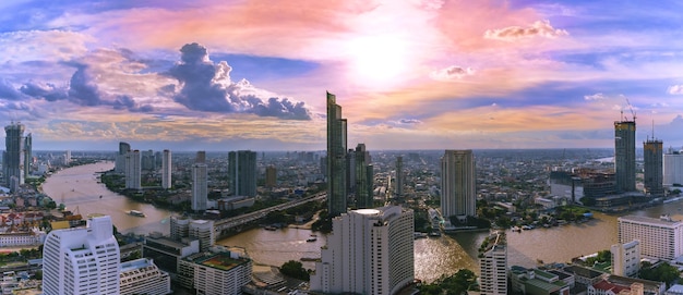 Panoramic cityscape of Bangkok in the evening viewing Taksin bridge crossing Chao Phraya River and  skyscrapers along the river , Thailand