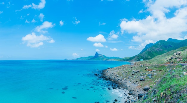 Panoramic coastal Con Dao view from above with waves coastline clear sky and road blue sea