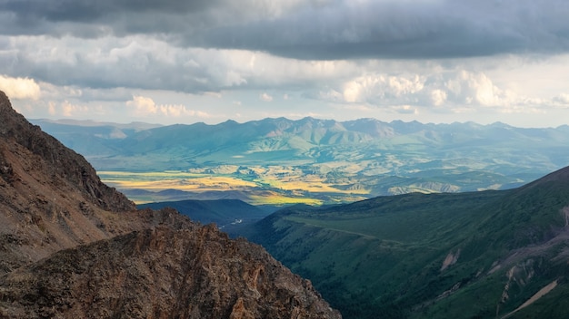 Panoramic mountain landscape of motley mountain valley in sunlight. Wonderful sunny highland scenery of multicolor valley. Unusual fantasy landscape.