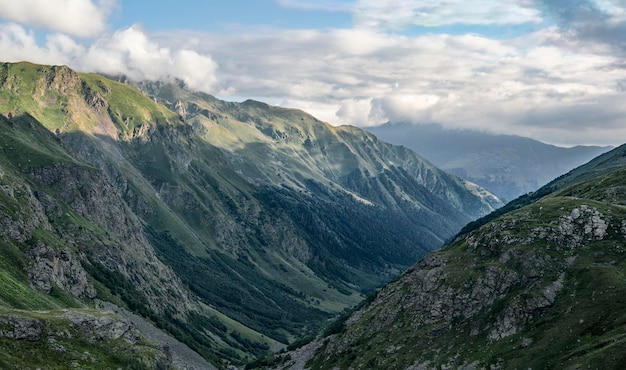 Panoramic mountain range with dramatic cloudy sky at sunset or sunrise