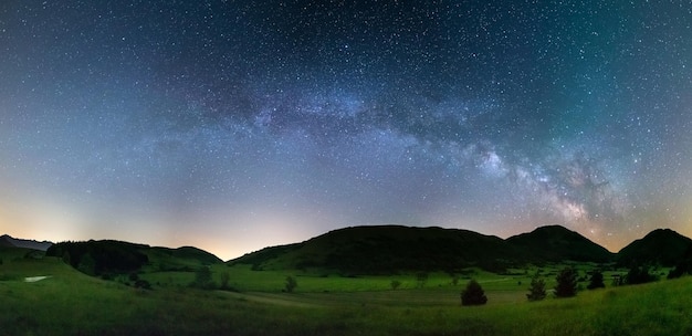 Panoramic night sky over Montelago highlands Marche Italy The Milky Way galaxy arc and stars in unique hills landscape