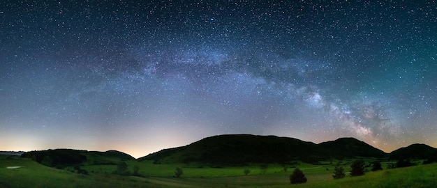 Panoramic night sky over Montelago highlands Marche Italy The Milky Way galaxy arc and stars in unique hills landscape