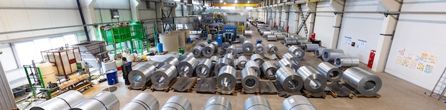 Panoramic photo of production line of metal tile for roof. Steel forming machine in metalwork factory workshop. Metal sheet profiling machine. Background of plant