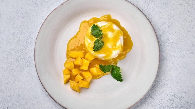 Panoramic top view panna cotta with natural vanilla pod mango syrup and mint