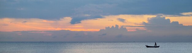 Photo panoramic view of amazing sunset and traditional asian boat on a tropical island