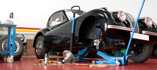 Panoramic view of antique automobile being repaired in the mechanic workshop