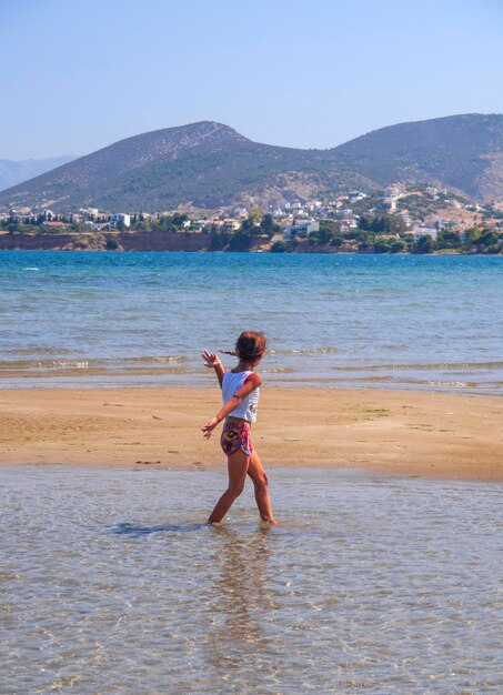 Panoramic view of the city beach of Liani Ammos and children playing in the sea in Greece