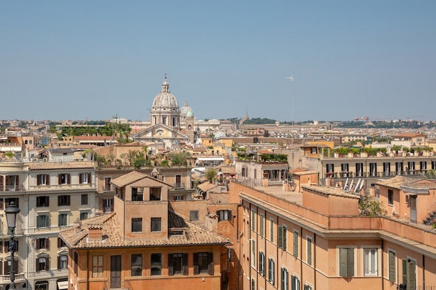 Panoramic view of city Rome with old houses from the Spanish steps. Summer sunny day and blue sky