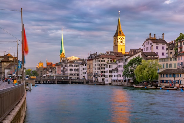 Panoramic view of famous fraumunster and church of st peter and river limmat at sunset in old town o