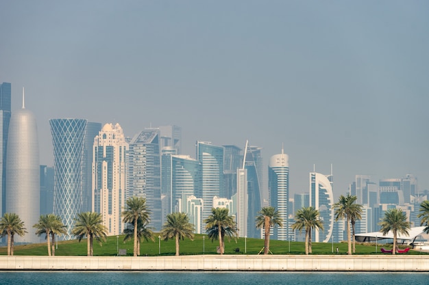 Panoramic view of modern skyline of Doha with Palms foreground. Concept of healthy environment.