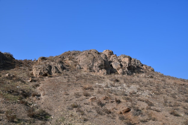 Panoramic view of the mountain. Large stones on the top of the mountain. Mountain against the blue sky.