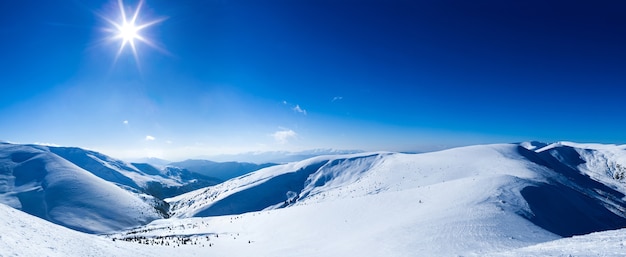 Panoramic view of mountains covered with snow on clear winter frosty day