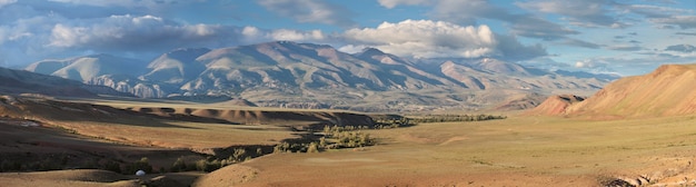 Panoramic view of mountains in the south of Altay, Mongolian landscapes. Dry mountain slopes, picturesque sky and evening light.