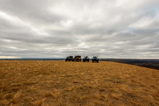 Panoramic view of Quad bikes in field on cloudy day