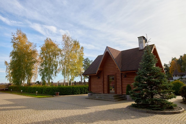 Panoramic view of a rural country house made of wooden beams and ornamental plants