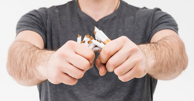 Photo panoramic view of smiling man breaking cigarettes with two hands