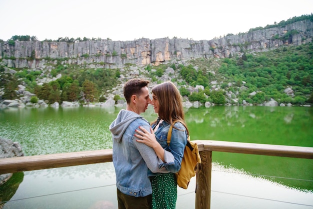 Panoramic view of young couple kissing on pathway with lagoon in the background. Horizontal view of couple traveling in the black lagoon in Soria. People and travel destinations in Spain.