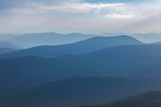 Panoranic blue view of mountain hills and meadows during sunset