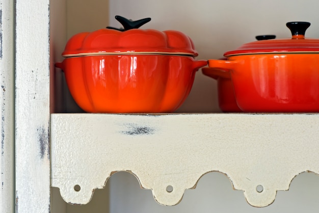 Pans of refractory porcelaine on white cabinet shelf