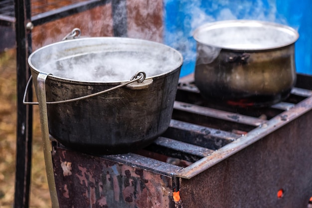 Pans with food stand on the brazier with fire