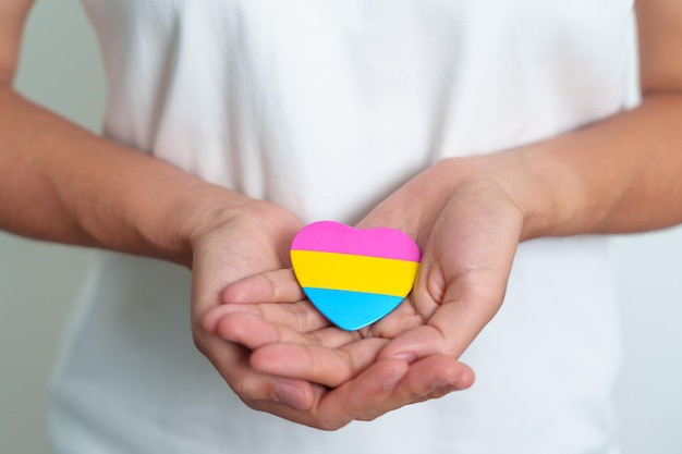 Pansexual Pride Day and LGBT pride month concept hand holding pink yellow and blue heart shape for Lesbian Gay Bisexual Transgender Queer and Pansexual community