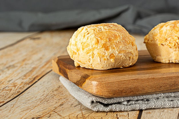 Pao de queijo a traditional brazilian food made of chesse bread over wooden table and cutting board