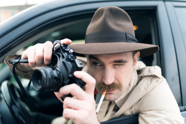 Paparazzo using vintage camera in his car