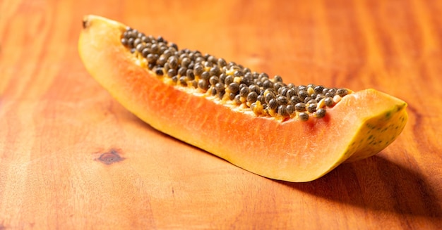 Papaya details of a slice of papaya sliced over rustic wood selective focus