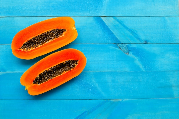 Photo papaya fruit on blue wooden background