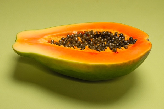 Photo papaya fruit on a green background. tropical fruit. half papaya.