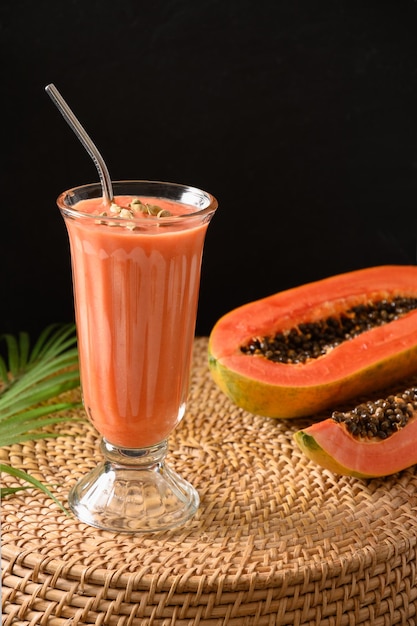 Papaya lassi in glass on black background