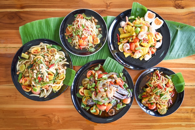 Papaya salad served on dining table Green papaya salad spicy thai food on plate with fresh vegetables