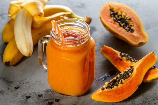 Papaya smoothie in a jar with papaya slices