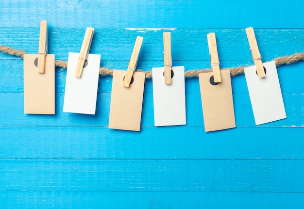 Paper attach to rope with clothes pins on wooden background