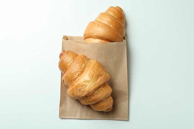 Paper bag with croissants on white