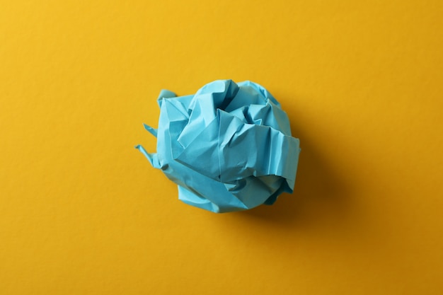 Paper ball on yellow background, close up