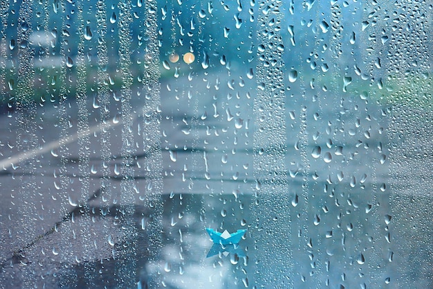 paper boat in a puddle of rain / autumn weather concept childhood