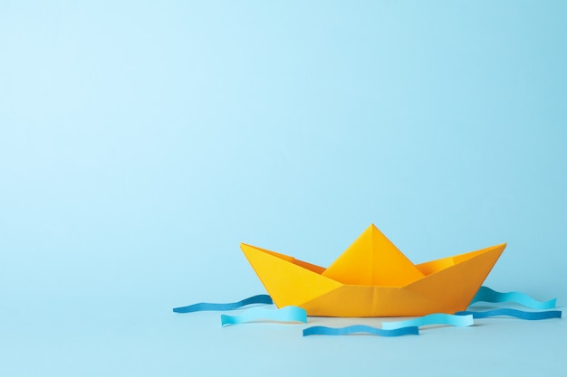 Paper boat and waves on blue, space for text