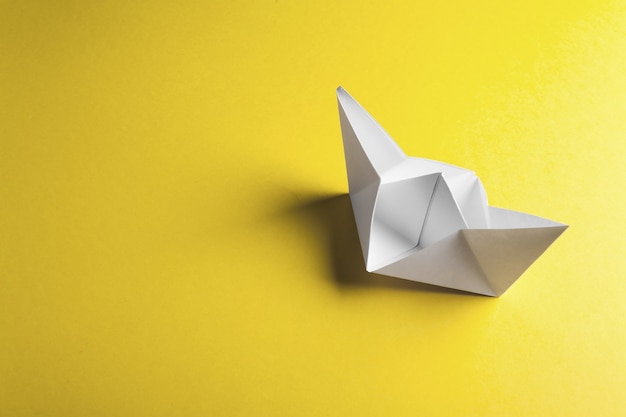 Paper boat on a yellow surface