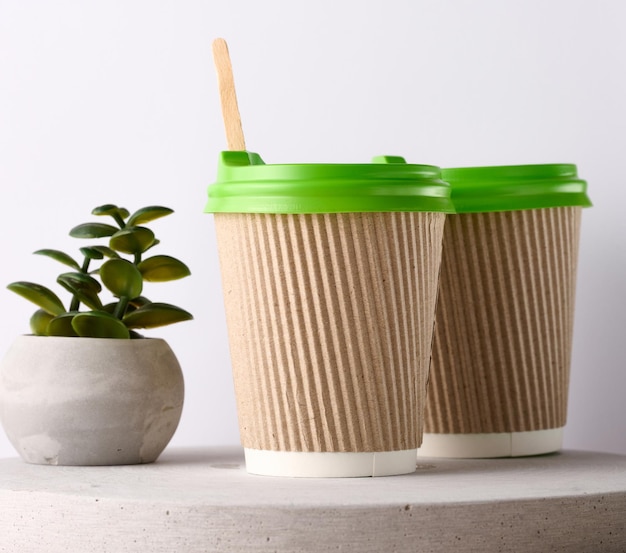 Paper brown cups with a plastic green lid for coffee and tea