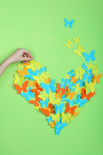 Paper butterflies on green wall background