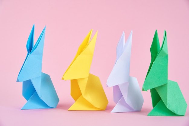 Paper colorful origami Easter rabbits on pink