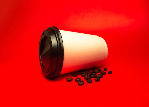 paper cup of coffee with beans on a red background