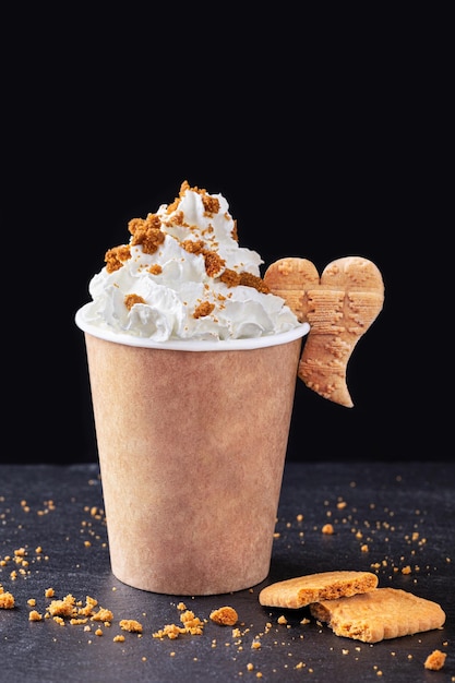 Paper cup with hot drink with whipped cream on dark background Recycling and eco friendly concept