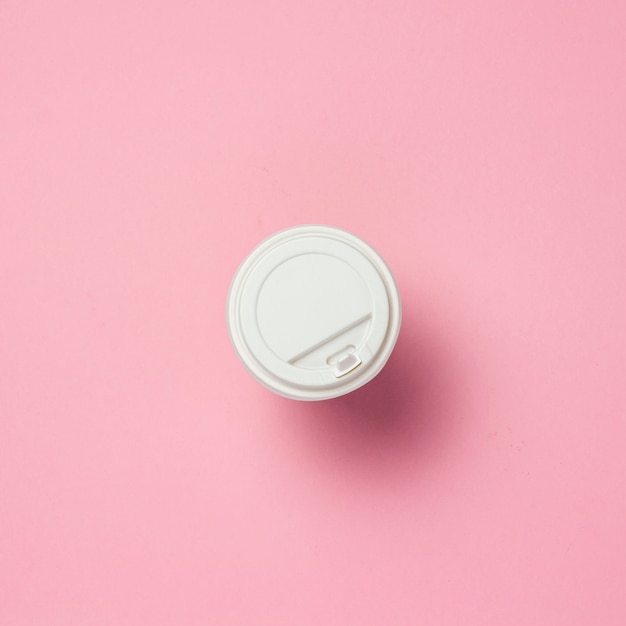 Paper cup with a plastic lid, coffee or tea, on a pink background. Fast food concept, bakery, breakfast, sweets, coffee shop, take-away food. copy space. Flat lay, top view.