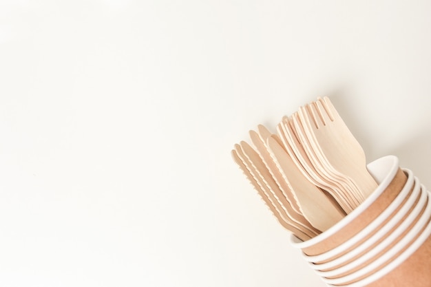 Paper cup and wooden cutlery with copy space