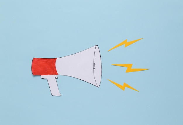 Photo paper cut cartoon megaphone on blue background